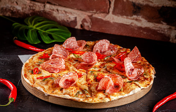 Neapolitan, Mexican cuisine. Pizza with salami sausage, with red pepper, jalapenos, pickled cucumbers and tomato pilati sauce. background image, copy space text