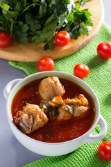 Chakhokhbili with chicken legs, parsley and tomatoes on a gray background. Chicken in tomato sauce.