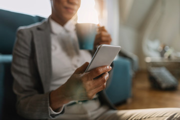 Close-up of black businesswoman texting on smart phone.