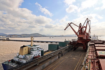 Cargo terminal for unloading grain cargo by shore cranes. Port Zhoushan, China. November, 2019.