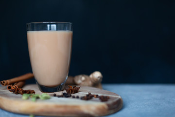 Traditional indian drink - masala tea with spices on black stone background
