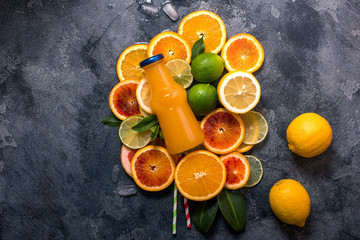 Citrus juice in bottle on sliced citrus fruits