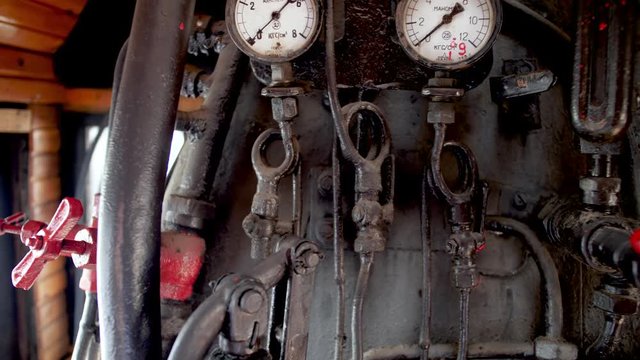 4k dolly video of vintage steam locomotive boiler with pipes, valves, gauges and indicators