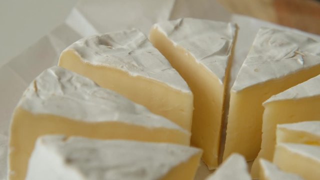 Sliced sectors of soft cheese brie or camambert rotating, close up