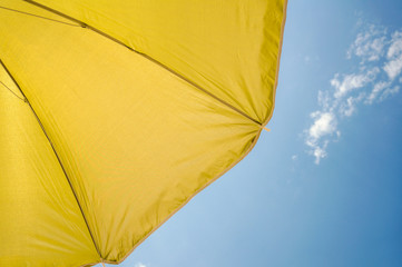 yellow umbrella on blue sky with clouds. Happy holiday vacation concept