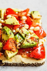 Avocado, hummus and tomato toast with seedlings. Healthy vegan food concept.