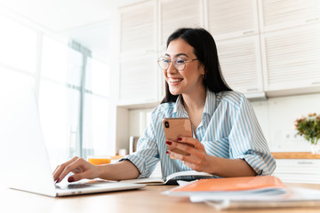 Happy brunette young woman using laptop computer