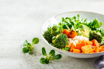 Vegan lunch bowl with rice, broccoli, sweet potato, rice and salad. Vegan food concept.