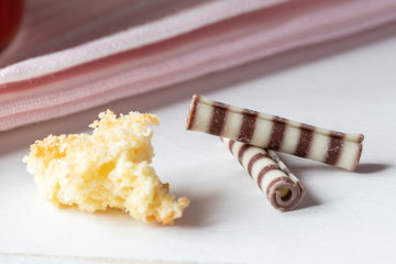 rot weißer Erdbeer Käse Sahne Kuchen im Glas mit Boden Biscuit auf hellem Grund mit rosa Küchentuch