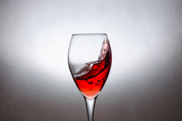 glass of red wine on a white background in motion. Freezing liquids in motion