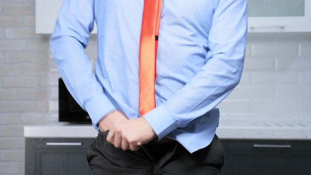 weight loss concept. man hardly fastens his pants, on a thick stomach