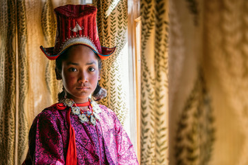 Portrait of a beautiful young girl in typical tibetan clothes with hat in Ladakh, Kashmir, India - 325677773