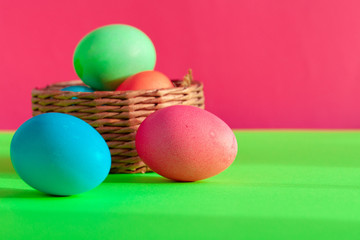 Vibrant colored eggs in a nest on green. Easter concept