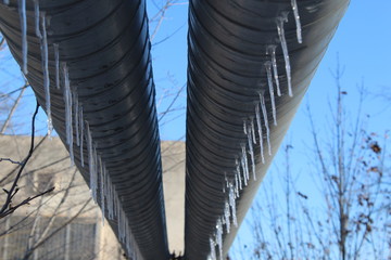 Naklejka premium Icicles on the pipe. Frozen water in winter