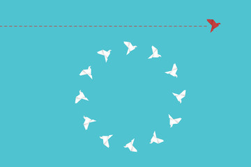 Think differently concept. Be different. Red bird changing direction. New idea, change, trend, courage, creative solution, innovation and unique way concept.	