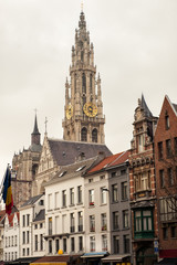 Fototapeta na wymiar Vertical view of bell tower of Cathedral of Our Lady in Antwerp, UNESCO world heritage site in Belgium with flemish houses around. Popular travel tourism destination in Benelux