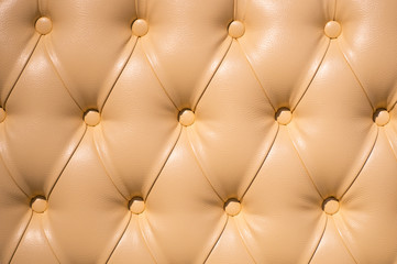 Coach-type velours screed tightened with buttons. Chesterfield style quilted upholstery backdrop close up