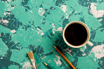 cup of coffee, brush and pencils on a blue-blue background.