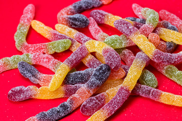 jelly worms sweets on red background