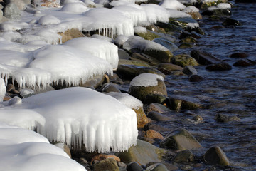 Icy stones on coast. Winter seascape