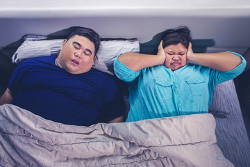 Fat Asian man snoring while sleeping with his wife