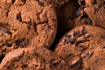 Appetizing chocolate chip cookies with slices of raisins on a black background.