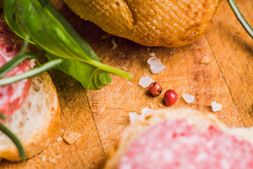 Bread with salami on the wooden background. Shallow depth of field.
