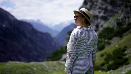 Breathtaking scenery view of high rock cliffs in alps, slow motion effect of female tourist in hat and casual wear explore nature landscape and mountain on trekking tour