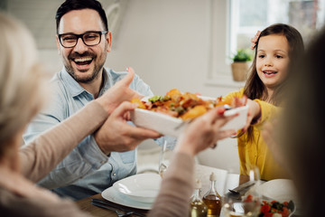 Cheerful family having lunch together in dining room.