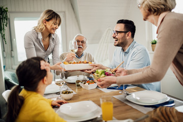 Happy extended family enjoying in family lunch in dining room.