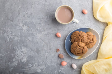 homemade oatmeal cookies with a cup of cocoa on a gray concrete background. top view, copy space.