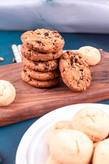 Chocolate chips cookies and butter biscuits on a wooden board