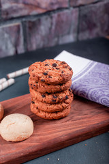 Butter and oatmeal cookies on a wooden cutting board on a blue table