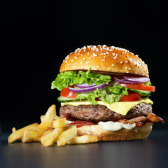 Fresh burger with french fries on dark background