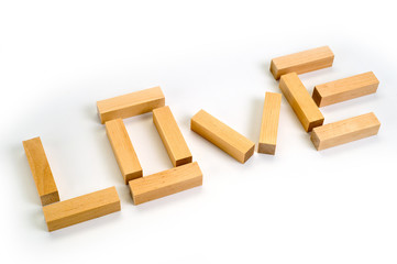 The word Love laid out by wooden blocks on a white background. Background for love and romance.