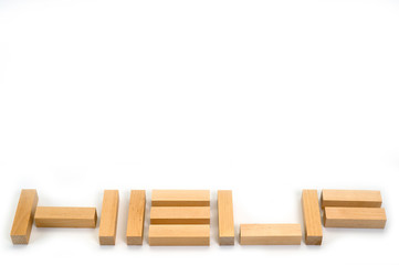 The word Help laid out by wooden blocks on a white background. Background to help those in need.