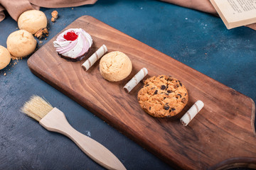 Vanilla meringue cake with cookeis on a cutting board. 