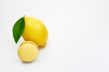 Fruit lemon with yellow macarons on a white