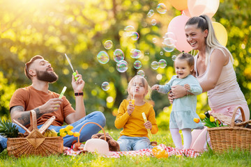 Happy family having picnic in the park - obrazy, fototapety, plakaty