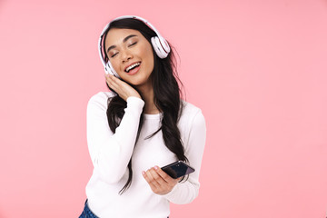 Cheerful pretty young asian woman listening to music