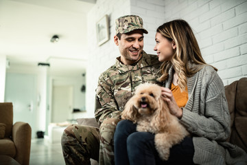 Young happy military man talking to his wife at home.