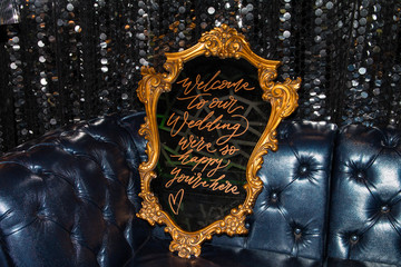 Writings on a vintage style mirror. Antique decorative mirror on a sofa.