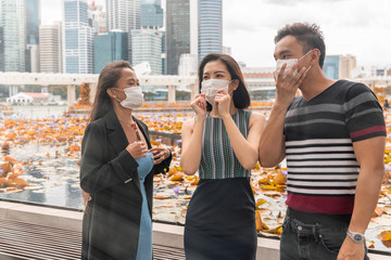 Three asian young friends enjoying outdoor time together wearing hygienic mask to prevent the virus PM2.5 and Coronavirus. Air pollution, Environmental awareness concept