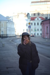 Fototapeta na wymiar Young beautiful girl eating croissants on the street
