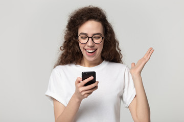 Fototapeta premium Excited attractive millennial girl received promo offer sms.
