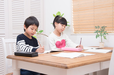 ダイニングで勉強をする小学生の子供