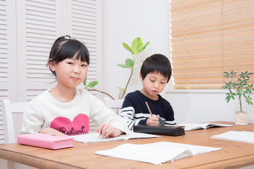 ダイニングで勉強をする小学生の子供