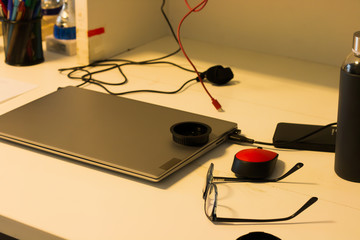 MESA DE TRABAJO DESORDENADA CON PORTATIL, GAFAS Y OTRAS COSAS