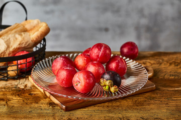 Red plums in a glass fruit plate