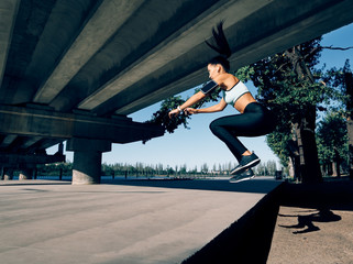 Fototapeta na wymiar Fit young woman doing sport jumps outdoors